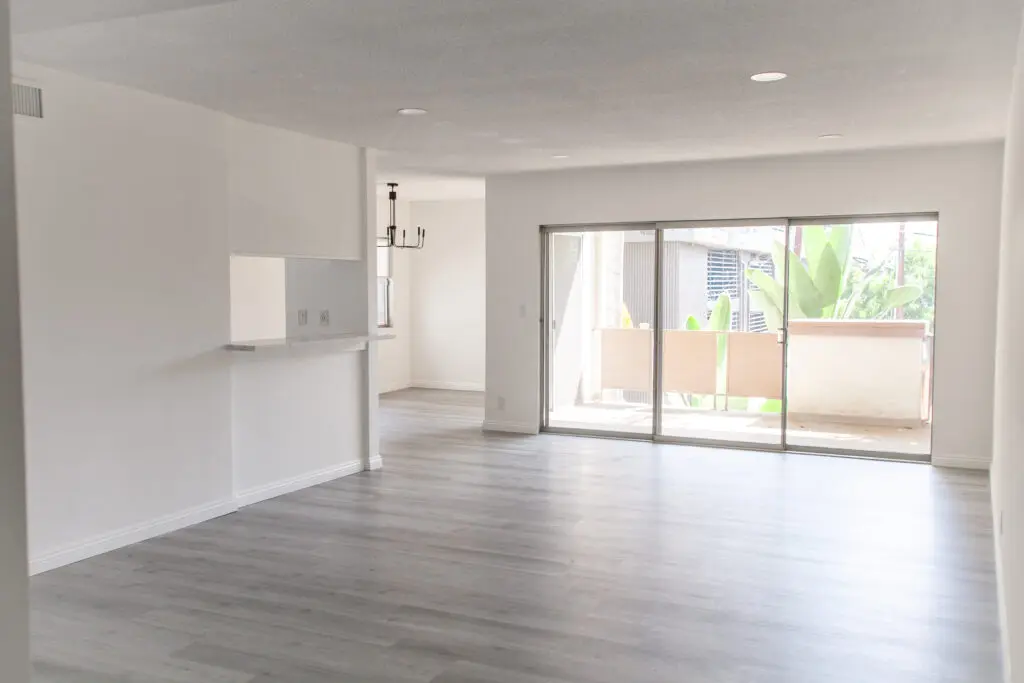 Empty modern living room with large windows.