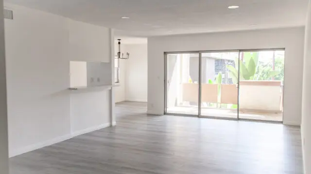 Empty modern living room with large windows.