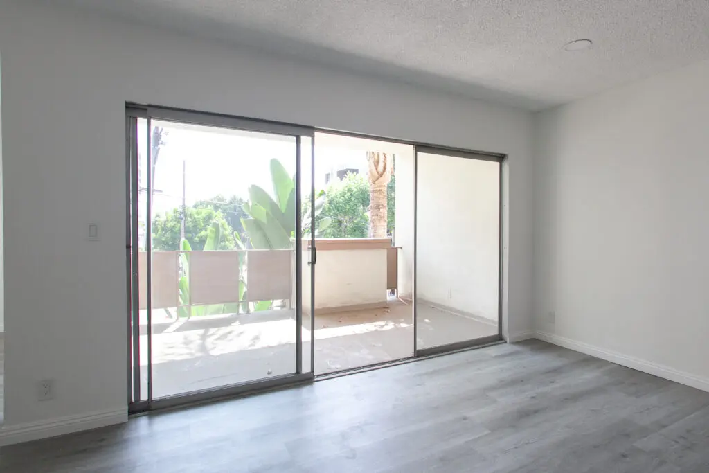 Empty room with sliding glass doors and balcony.