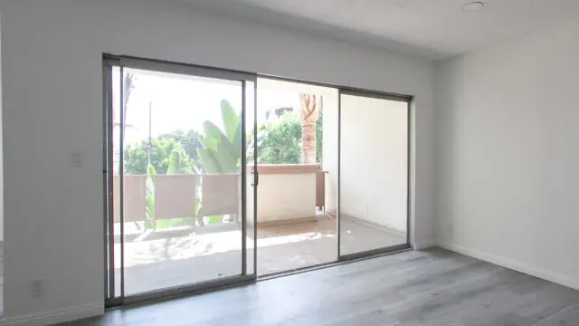 Empty room with sliding glass doors and balcony.
