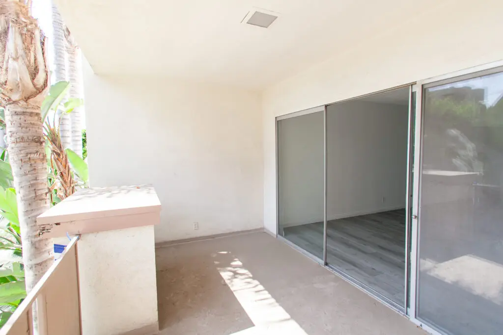Empty balcony with sliding glass door.