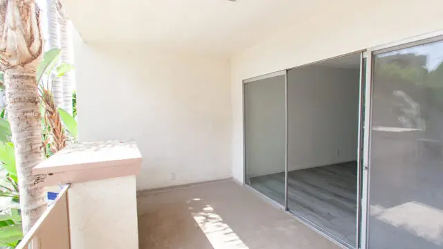 Empty balcony with sliding glass door.