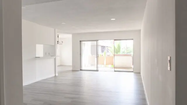 Spacious empty apartment with wooden flooring.