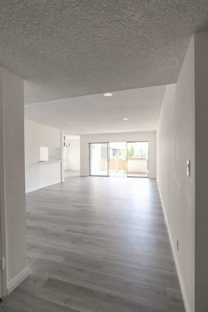 Spacious empty apartment with wooden flooring.