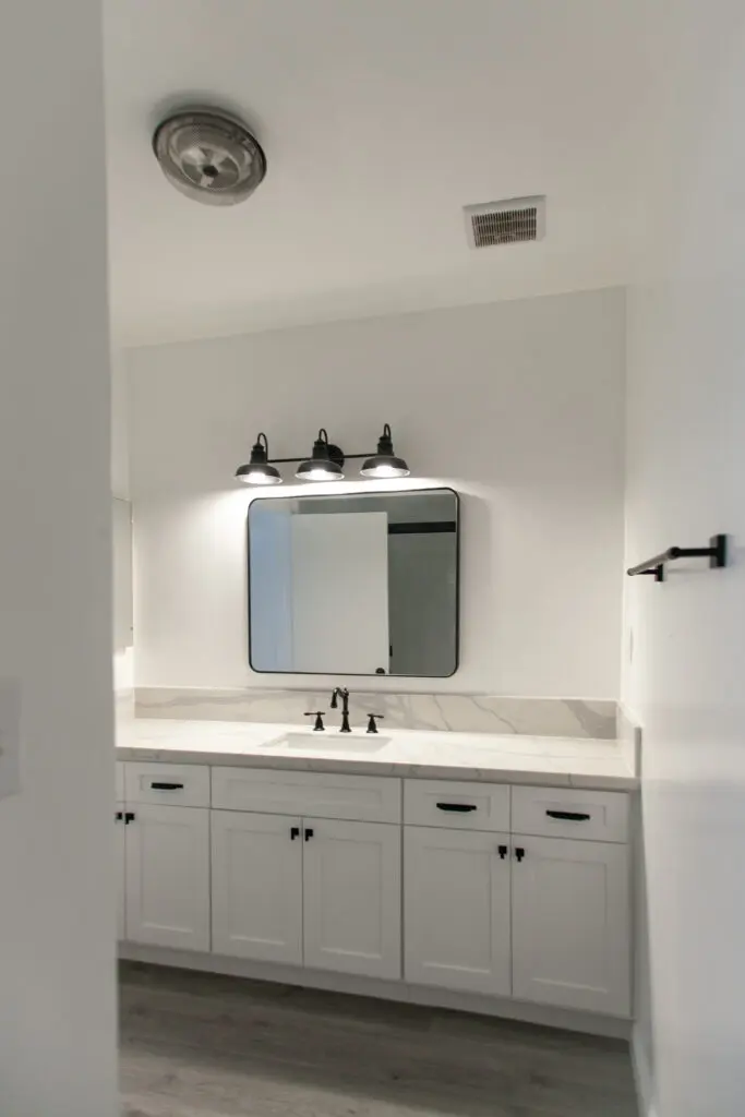 Modern bathroom vanity with mirror and lights.