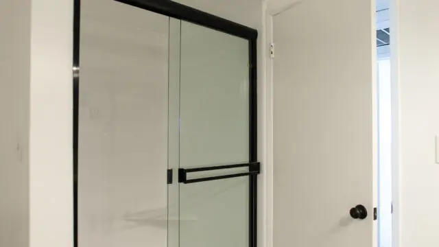 Bathroom with glass shower and open door.