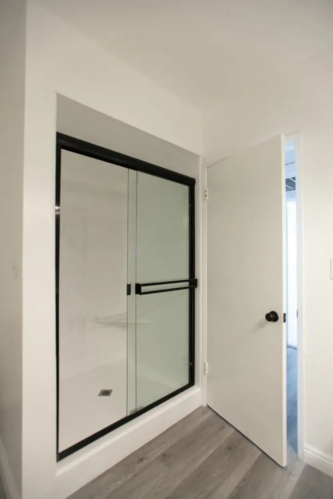 Bathroom with glass shower and open door.