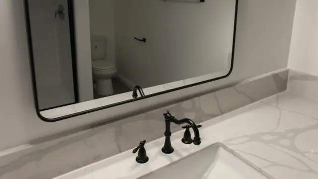 Modern bathroom with marble countertop and mirror.