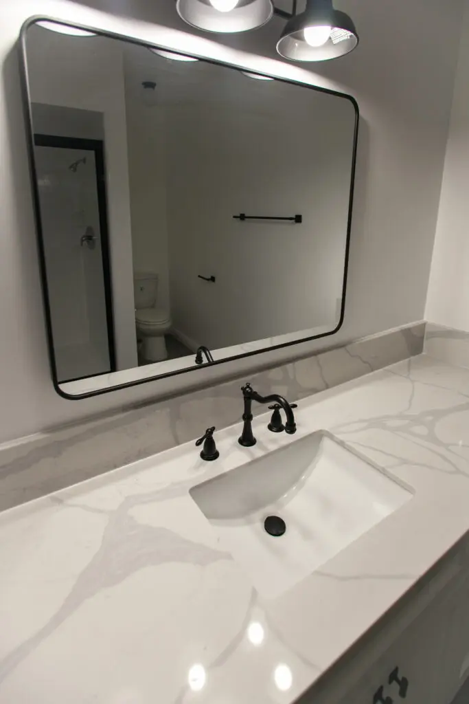 Modern bathroom with marble countertop and mirror.