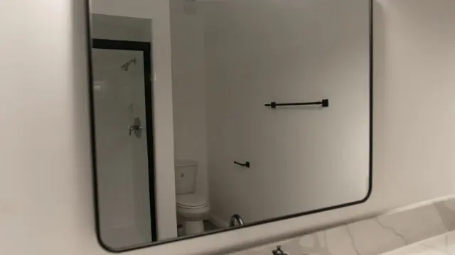Bathroom mirror with lights above sink.