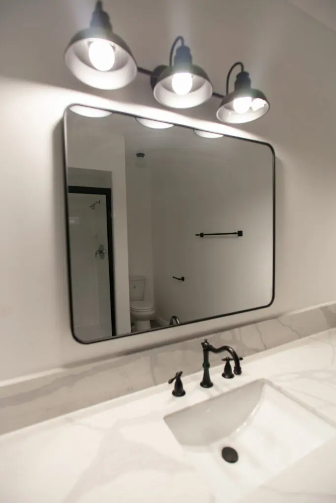 Bathroom mirror with lights above sink.
