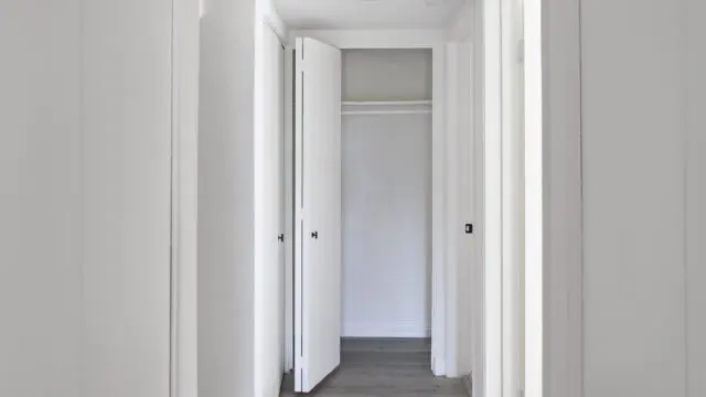 White hallway with open closet doors.