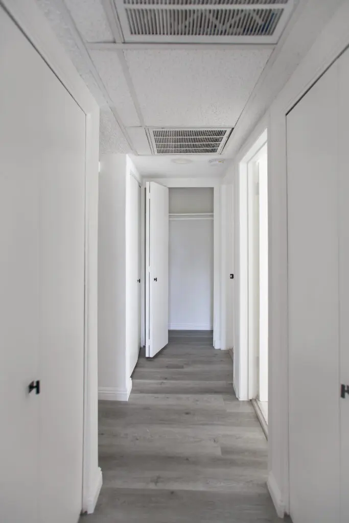 White hallway with open closet doors.