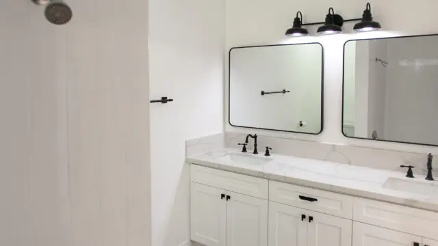 Modern white bathroom with double vanity mirrors.