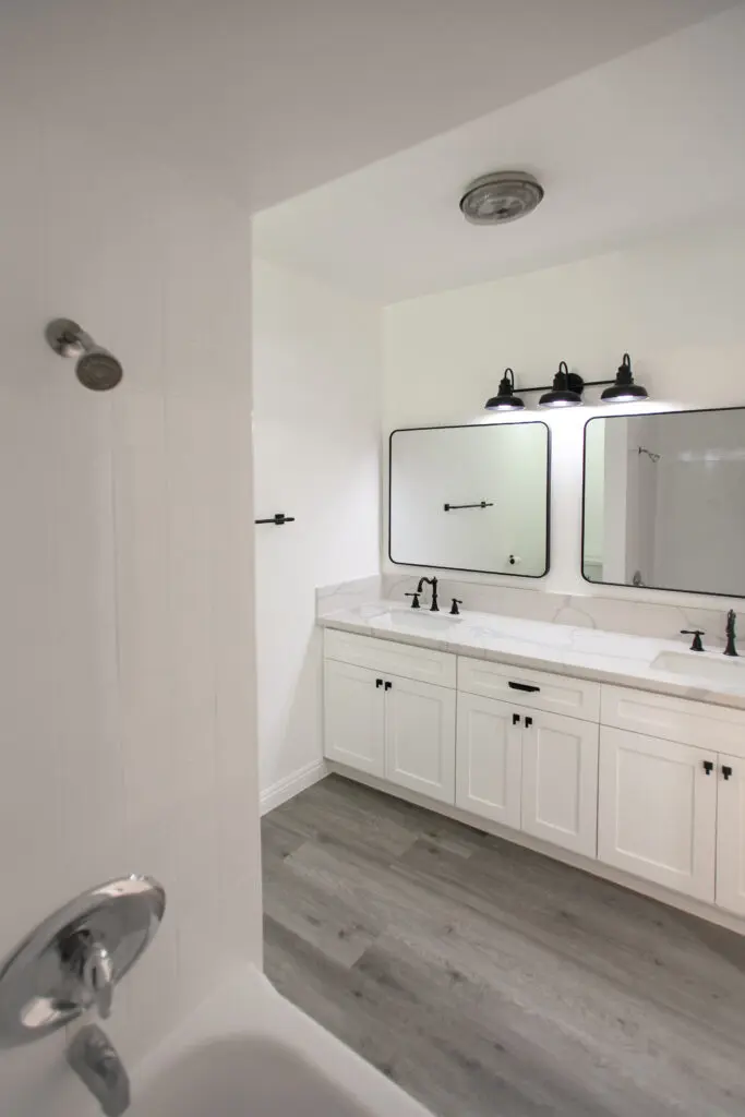 Modern white bathroom with double vanity mirrors.