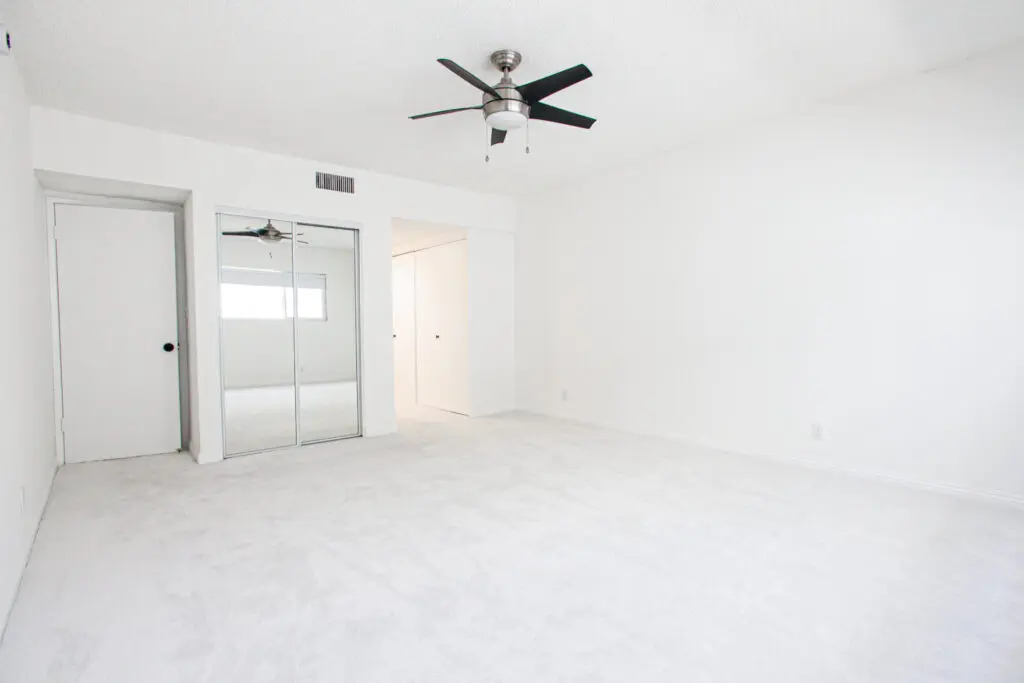 Empty white room with ceiling fan.