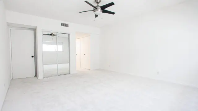 Empty white room with ceiling fan.